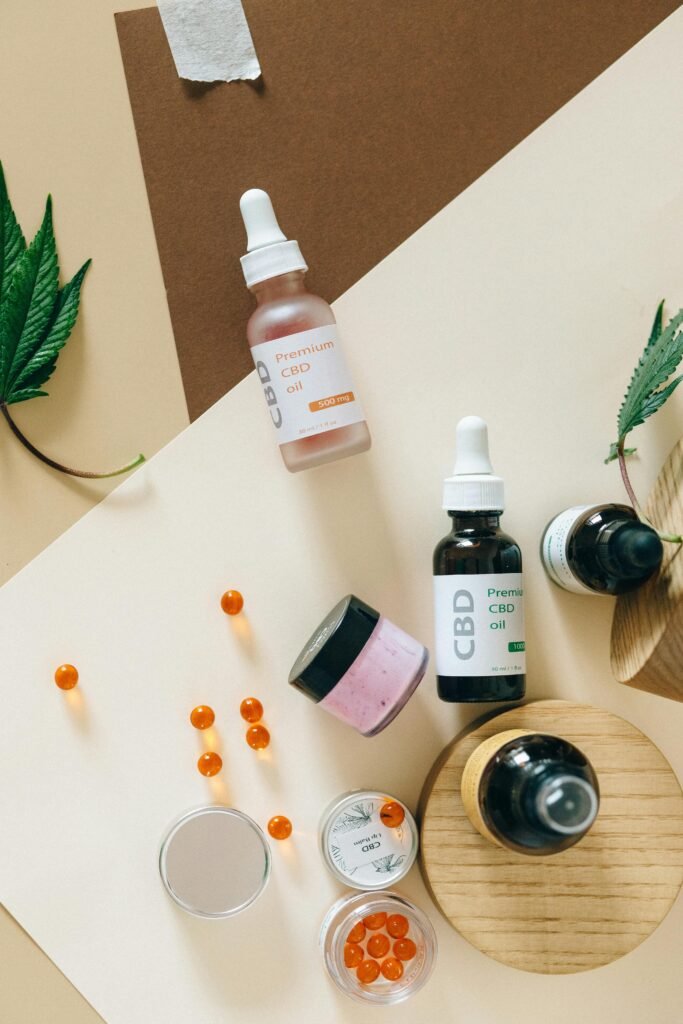 Arrangement of CBD oils, capsules, and leaves on a colorful background.